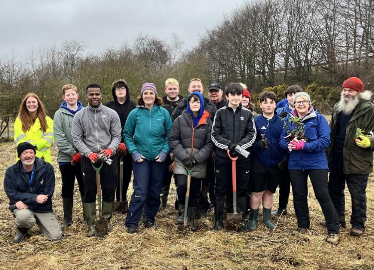 photo of staff and young people from Brechin High School, volunteers and representatives from Scotia Homes at the community garden planting trees