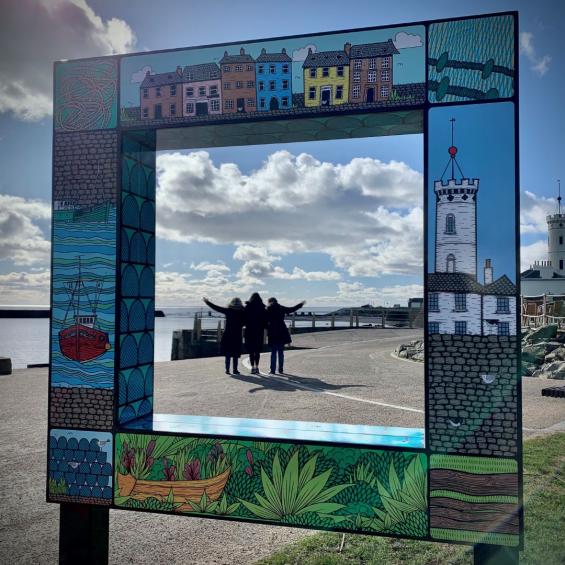 Staff from the The Glens Projects standing in front of new artwork they designed at Arbroath Marina