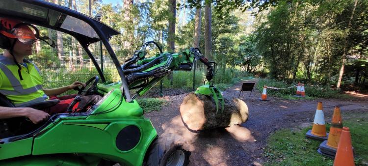 tractor lifting trees on path