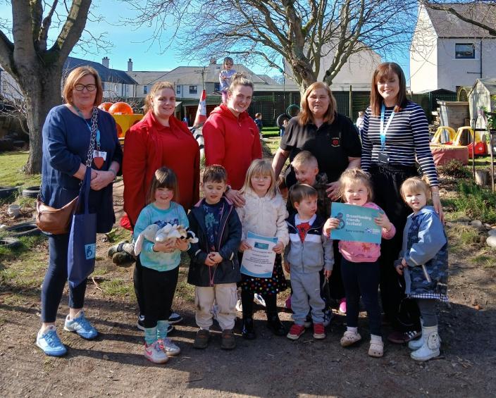 photo of some staff and young people at Ladybird Playgroup in Angus celebrating after achieving the Breastfeeding Friendly Award